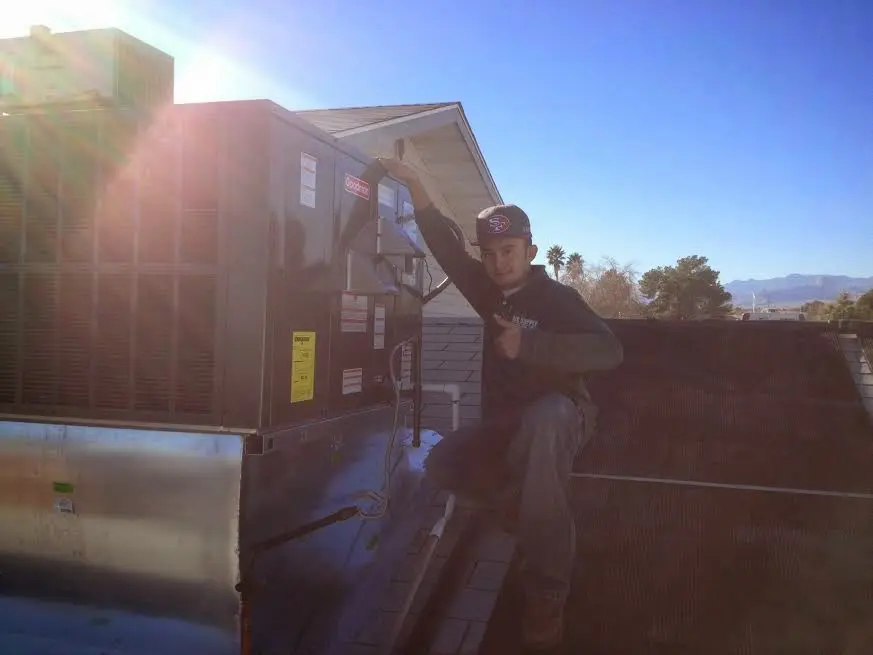 HVAC technician performing AC Tune-Up on a rooftop unit in Cazenovia